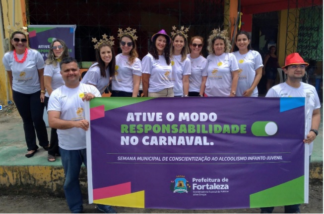 pessoas em pé posando para a foto segurando cartaz com mensagem